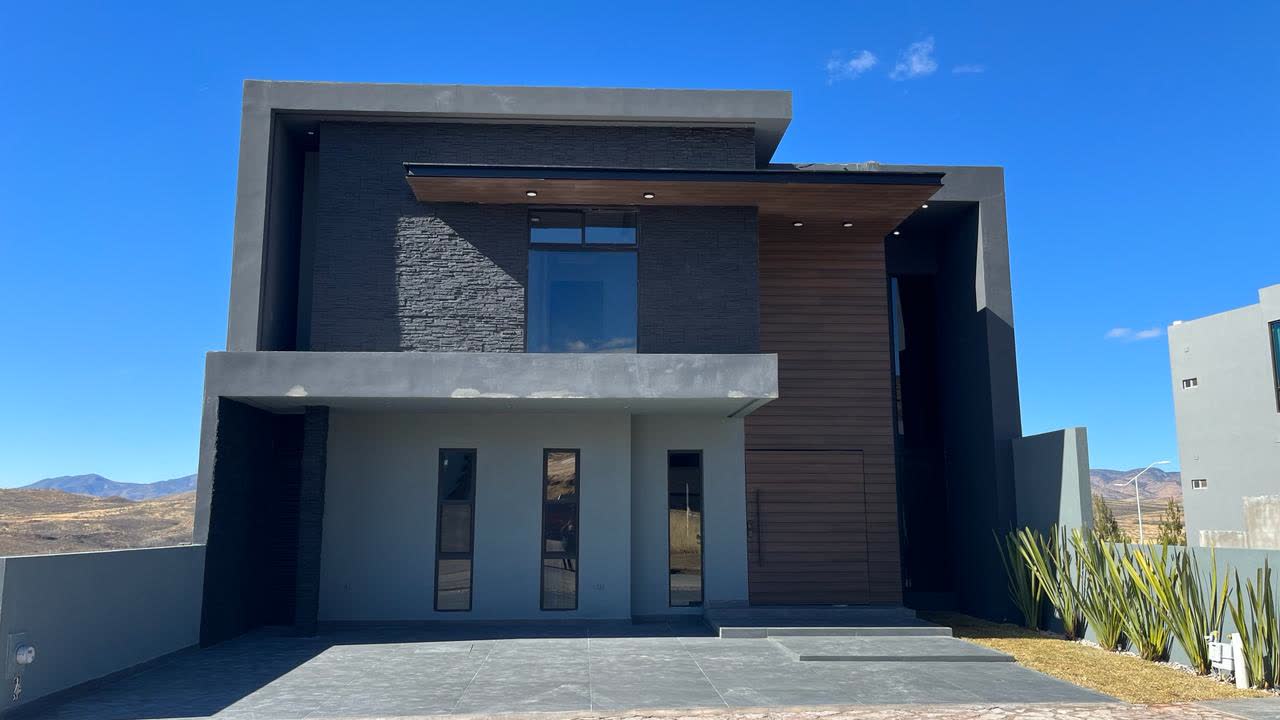 Fachada frontal de casa moderna construida por Grupo DST